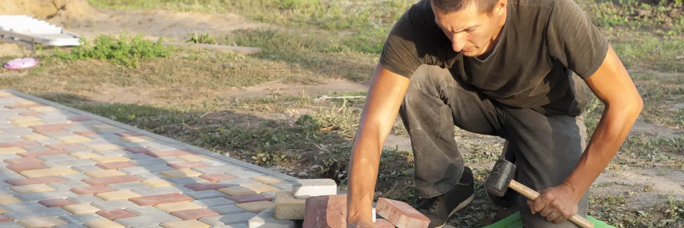 Brolægger er ved at lægge stenbelægning på terasse