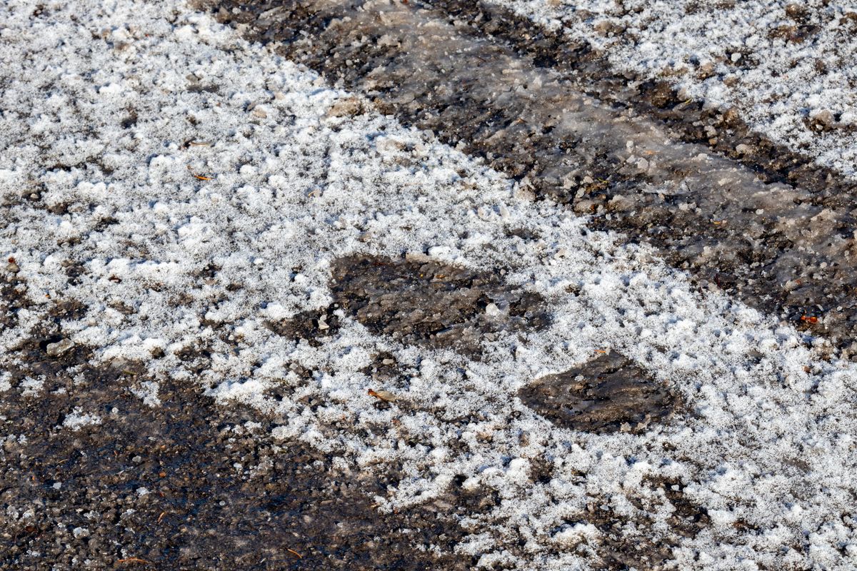 Fodspor i sneen på glat parkeringsplads